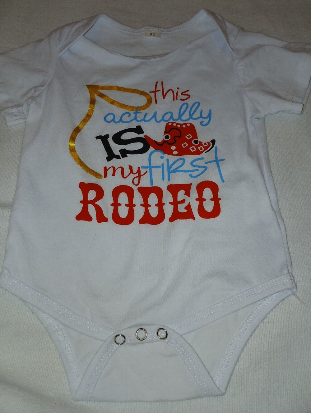 NWOT Infant's White "This Is My First Rodeo" Baby Onesie.